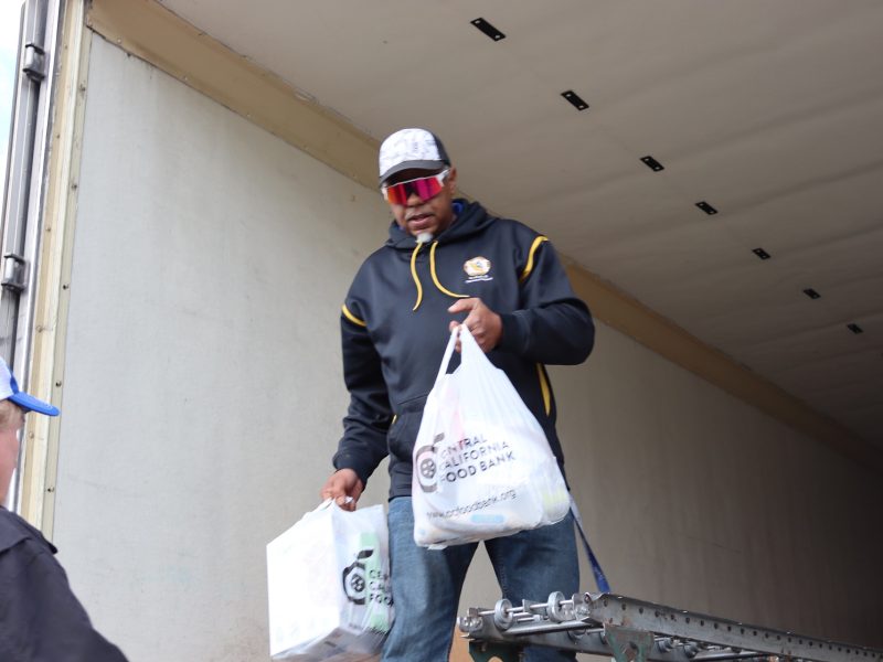 End of final distribution of the day as Specialist Ronald Buckman hands bagged food stocks to tribal staff. Specialist Ronald Buckman hands bagged foods to California Valley Miwok Tribal staff Tiger Paulk during the 2023 USDA food distribution.