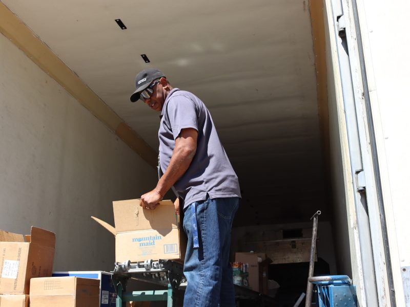 Tule River Tribe USDA delivery provider, Ronald Buckman at distribution. Ronald Buckman helping CMVT's staff member unloading the boxes of goods.
