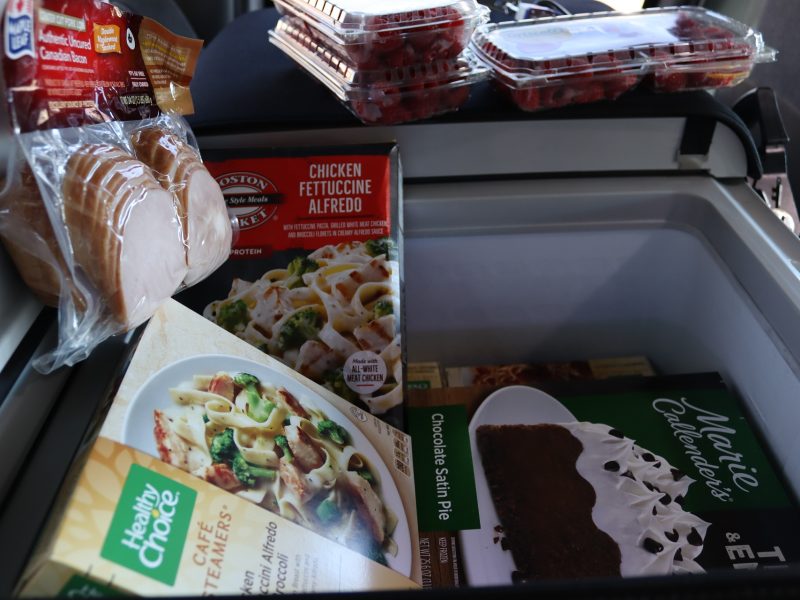 Various meats, frozen meals, fruits, and desserts.