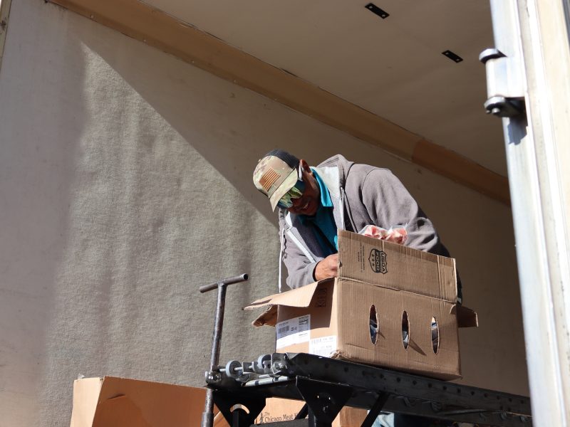 Beginning of distribution as Assistant Director Ronald Buckman puts meats into distribution. Ronald Buckman helping the California Valley Miwok tribal staff to unload goods.