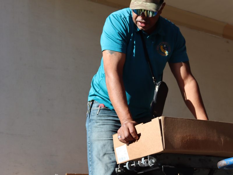 Ronald Buckman holding a box of goods for the Miwok tribal members.